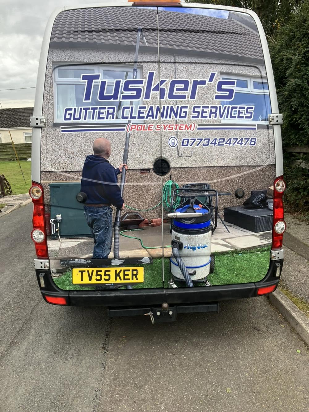 Gutter cleaning pole-system equipment at the rear of the Tuskers van